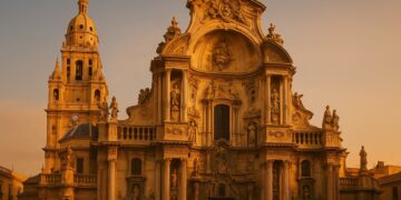 Fachada principal de la Catedral de Murcia iluminada por el atardecer, mostrando su riqueza barroca y monumentalidad.