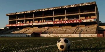 Estadio del Sporting de Gijón al atardecer con pelota en el césped, simbolizando la incertidumbre en el mercado de fichajes