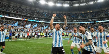 Jugadores de Argentina celebran un gol con euforia en el estadio rodeados de miles de hinchas con banderas celestes y blancas