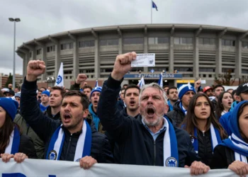 Aficionados del Deportivo con bufandas azules y blancas protestan frente al estadio sosteniendo pancartas y abonos