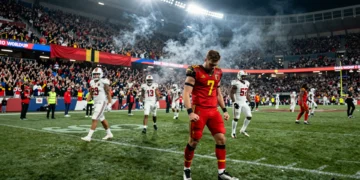 Jugador belga con jersey rojo celebra con los puños apretados en el estadio del Mundial 2026 tras eliminar a Estados Unidos
