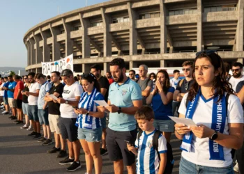 Aficionados del Deportivo haciendo cola frente a la fachada del estadio de Riazor con bufandas azul y blancas