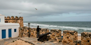 Viajero contemplando el Atlántico desde las murallas de la Sqala de la Ville en Essaouira, Marruecos
