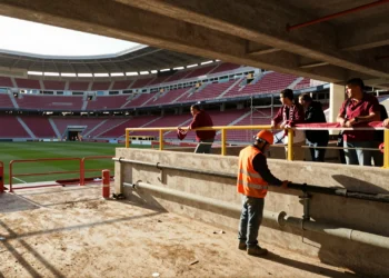 Obras de renovación en el estadio Enrique Roca del Real Murcia con obreros, andamios y aficionados observando