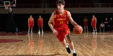 Mario Saint-Supéry, base español de 18 años, conduce el balón con la camiseta roja de la selección española de baloncesto