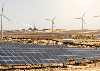 Paneles solares y aerogeneradores junto a un camión cisterna de gas en una llanura castellana bajo el sol mediterráneo