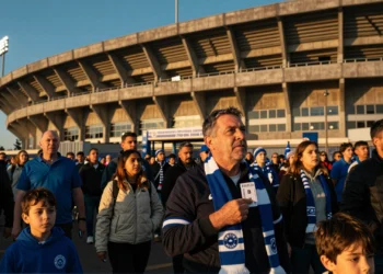 Aficionado del Deportivo sostiene su abono de temporada frente al estadio de Riazor al atardecer