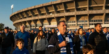 Aficionado del Deportivo sostiene su abono de temporada frente al estadio de Riazor al atardecer