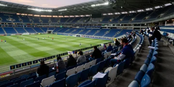 Grada de animación casi vacía en Riazor, con asientos azules y blancos desiertos y bufandas sin usar sobre los asientos