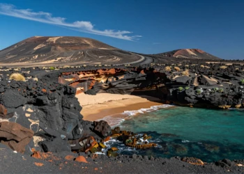 Costa volcánica del Parque Natural Cabo de Gata-Níjar con rocas negras, aguas turquesas y playa virgen de arena dorada