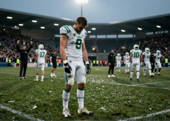 Jugador del Córdoba CF cabizbajo en el césped mojado del estadio tras una nueva derrota en el inicio de temporada