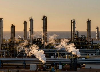 Complejo industrial de Valle de Escombreras en Murcia al atardecer, con torres de refinería y tuberías de acero