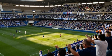 Aficionados del Huesca con bufandas azules y blancas en el estadio en el regreso al fútbol semiprofesional