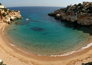 Vista aérea de Cala Cortina, bahía mediterránea de aguas turquesas con acantilados dorados junto a Cartagena