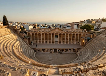 Teatro Romano de Cartagena con gradas de piedra caliza dorada y vista del Mar Mediterráneo al atardecer