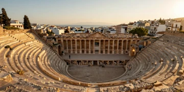 Teatro Romano de Cartagena con gradas de piedra caliza dorada y vista del Mar Mediterráneo al atardecer