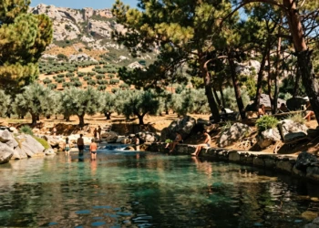 Piscina natural de aguas cristalinas en la Sierra de Segura, rodeada de pinos mediterráneos y olivares en Orcera, Jaén