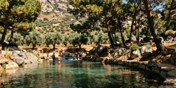 Piscina natural de aguas cristalinas en la Sierra de Segura, rodeada de pinos mediterráneos y olivares en Orcera, Jaén