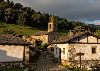Vista del pueblo navarro de Zugarramurdi con caseríos vascos, camino empedrado y bosque verde en los Pirineos