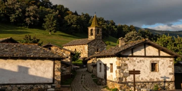 Vista del pueblo navarro de Zugarramurdi con caseríos vascos, camino empedrado y bosque verde en los Pirineos