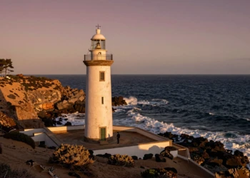 Faro andaluz sobre acantilado al atardecer con el océano Atlántico al fondo, desde Huelva hasta Almería
