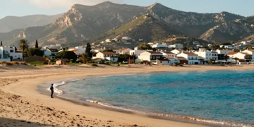 Playa dorada de Daimús con aguas turquesas del Mediterráneo y las montañas de La Safor al fondo, Valencia