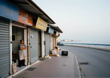 Comerciante de Ceuta ante tiendas cerradas con la costa de Marruecos al fondo durante la crisis migratoria