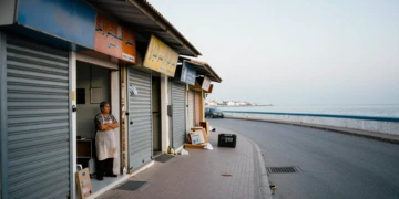 Comerciante de Ceuta ante tiendas cerradas con la costa de Marruecos al fondo durante la crisis migratoria