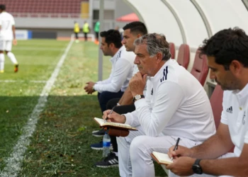 Mourinho sentado en el banquillo con un cuaderno en el debut de su etapa como entrenador del Real Madrid
