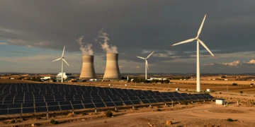 Turbinas eólicas y paneles solares junto a las torres de la central nuclear de Almaraz en Extremadura al atardecer