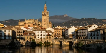Skyline histórico de Tarazona con la catedral mudéjar reflejada en el río Queiles y el Moncayo al fondo