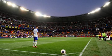 Futbolista en el círculo central de un estadio español repleto al atardecer, en el arranque de la temporada de LaLiga