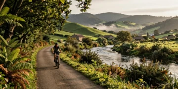 Ciclista en la Vía Verde del Besaya recorriendo un sendero verde junto al río en Cantabria, España