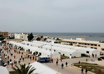 Campamento humanitario en Ceuta con tiendas blancas y bandera española, reflejando la crisis del plan de 309 millones